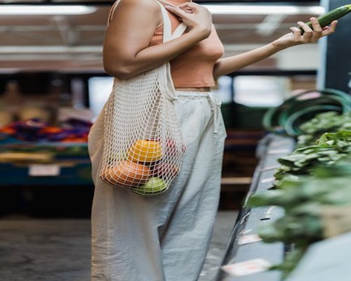Woman holding a reusable shopping bag in a local market